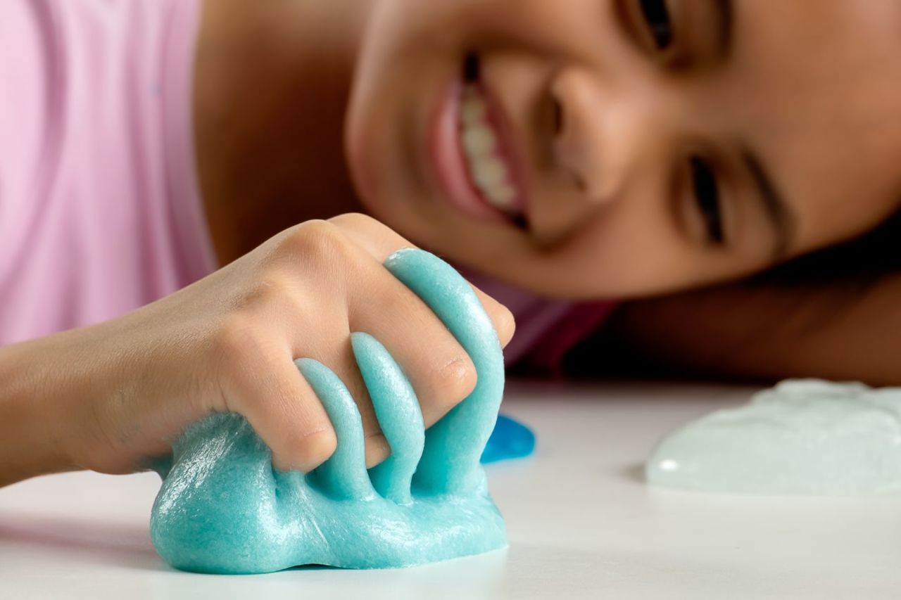 A girl squeezing gunge between her fingers.