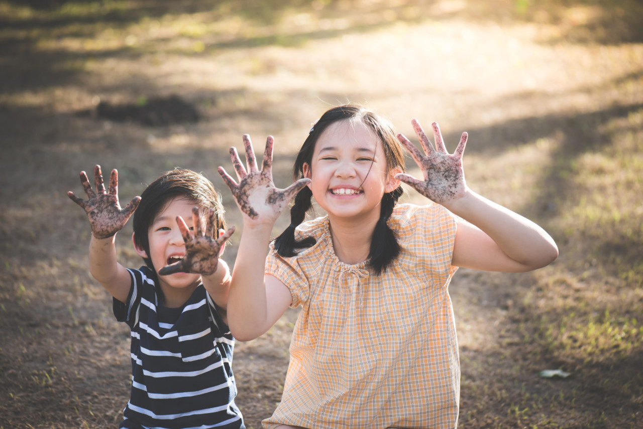 Children smiling with their hands up