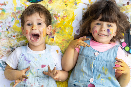 Two kids laughing on the floor