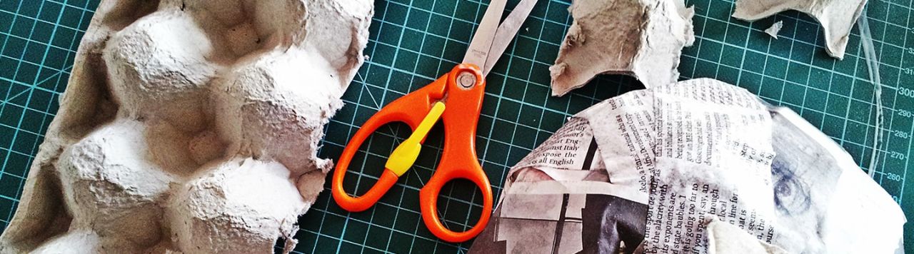 A paper mask being made using egg cartons and newspaper.