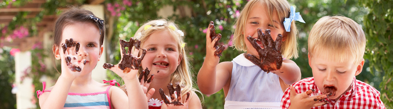 Criança com chocolate nas mãos