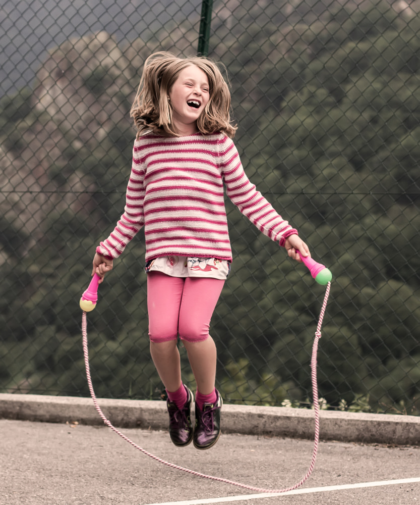 Menina brincando com uma corda de pular