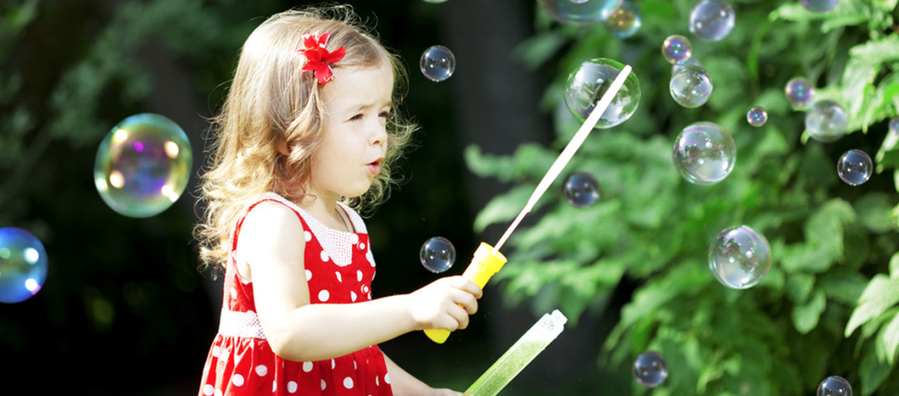 Criança brincando com um soprador de bolhas