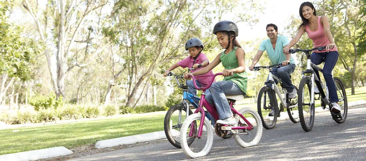 Happy family cycling in a park.