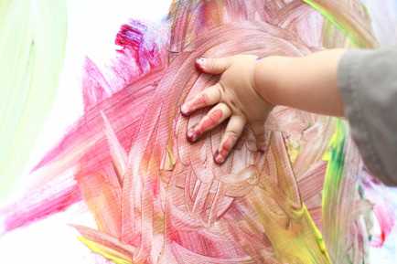 criança pintando com as mãos