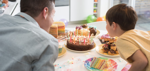 filho e pais soprando velas em um bolo