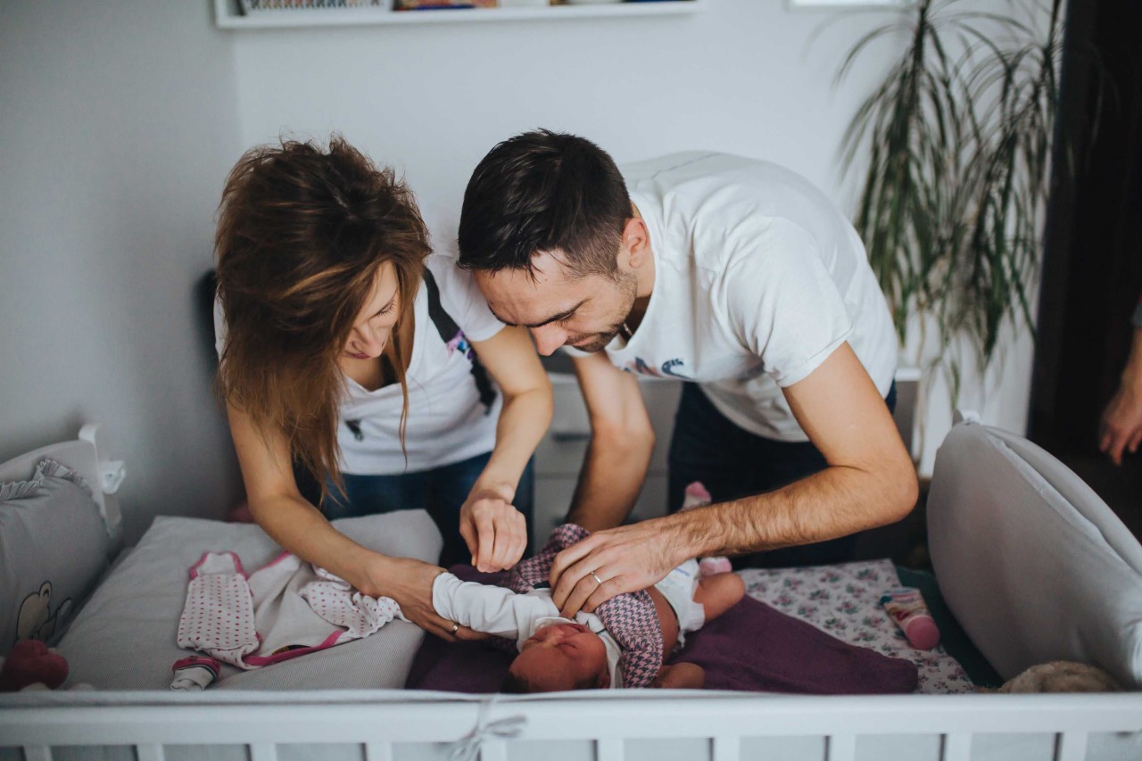 Padres vistiendo a su hijo