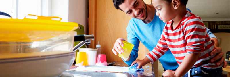 father and child cleaning dishes together