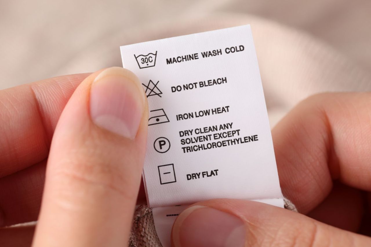 Uma etiqueta de roupa mostrando os símbolos da lavanderia com suas instruções.