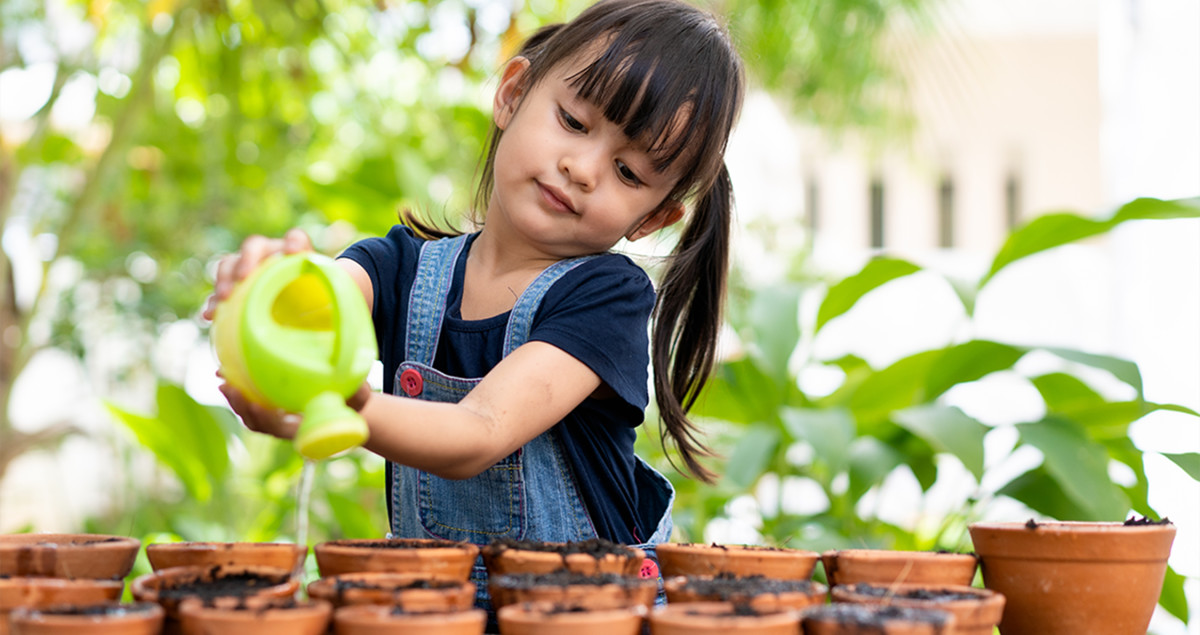 Little girl watering plants