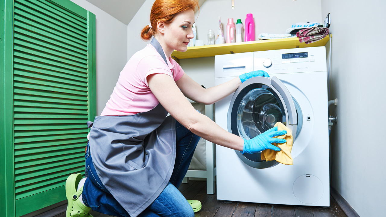 Çamaşır makinesini temizleyen kadın