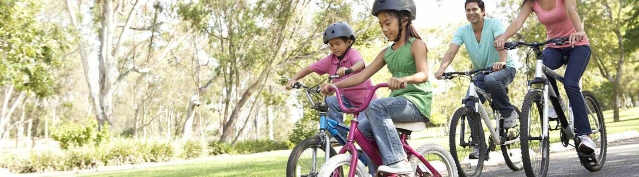 Happy family riding bikes in a park.