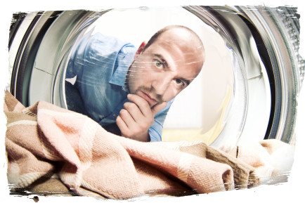 Çamaşır makinesinin içine bakan adam