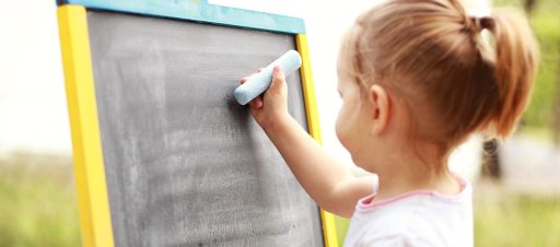 criança desenhando num quadro negro