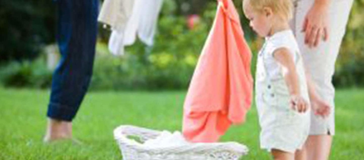 Lapsi auttaa ripustamaan pyykkiä