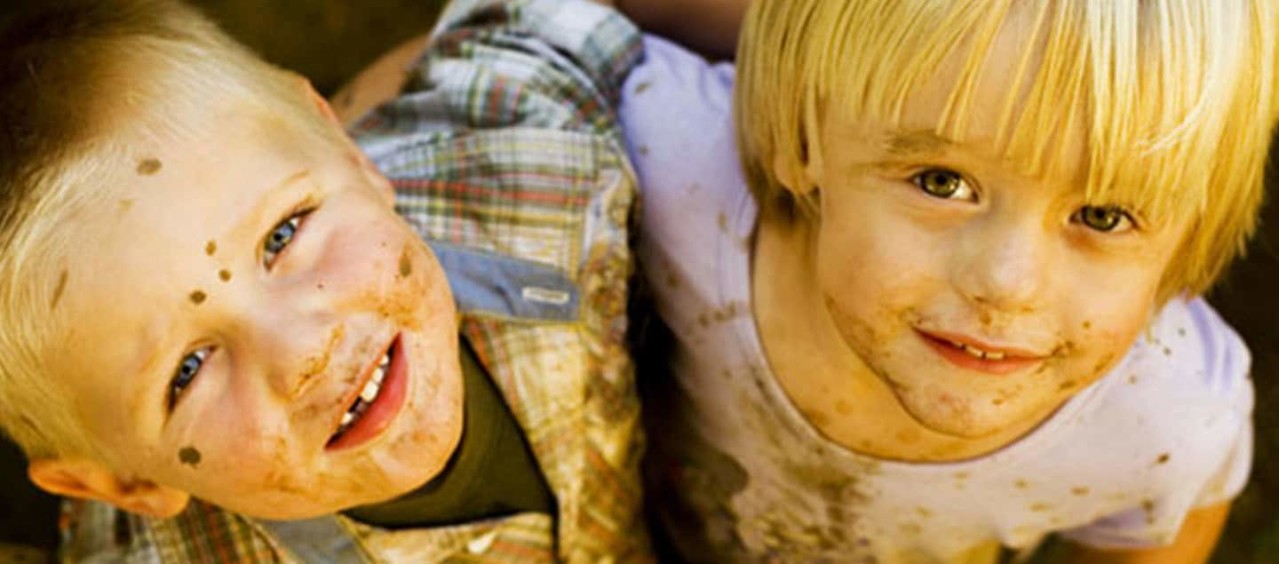 Två pojkar täckta med lera