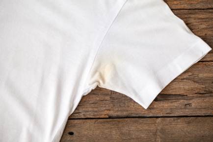 Uma camiseta branca com uma mancha amarelada nas axilas.