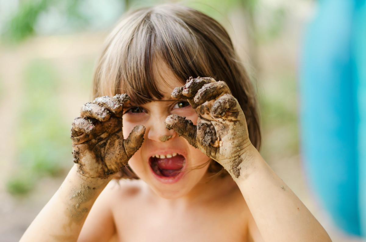 Child with mud on their hands