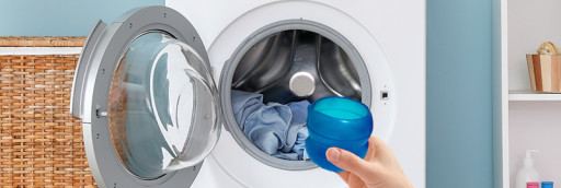 Çamaşır makinesine çamaşır kapsülü koyan kişi