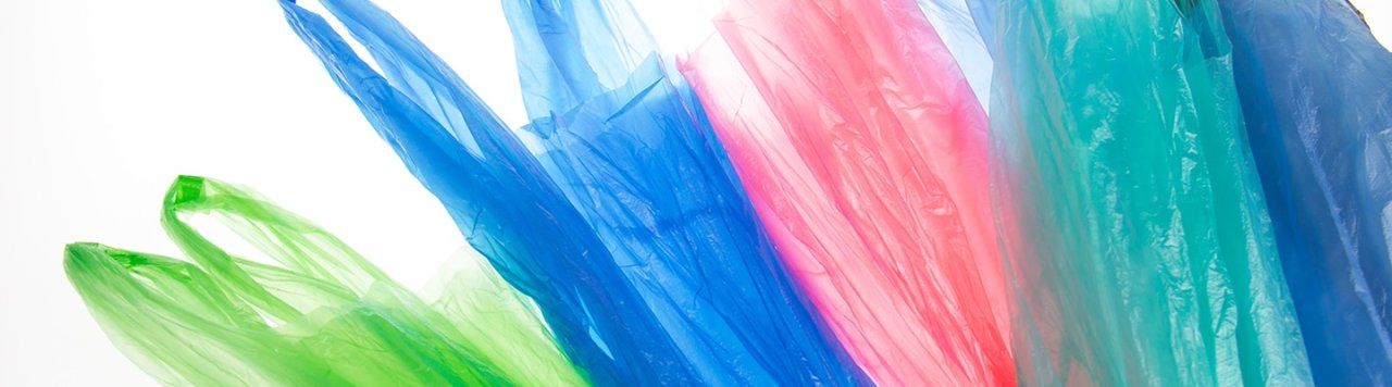Colourful plastic bags spread out on a white background.