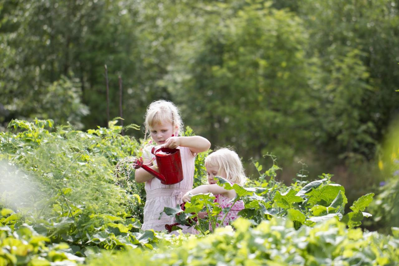 two young children watering plants