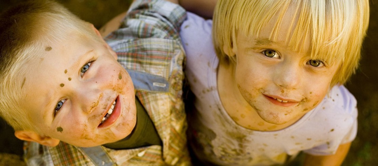 Two mud stained boys happily playing.