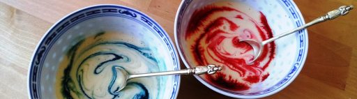 Milk tinted with food colouring in bowls.